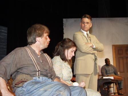 Atticus Finch (Robert Welch) glances at Bob and Mayella Ewell (T.J. DeLuca and Kate Colameco) as Tom Robinson (Kashmir Goins) gives testimony
