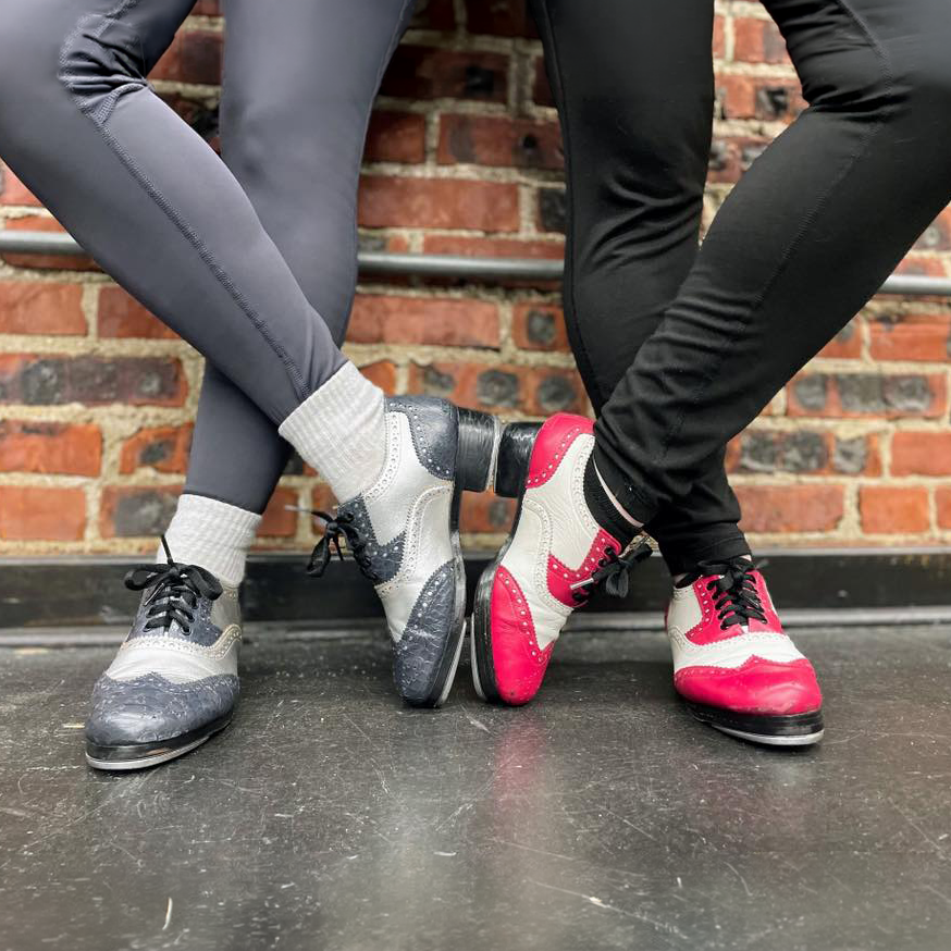 Two pairs of legs wearing tap shoes